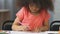 Young student at kindergarten coloring picture with pink pencil, development