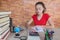 Young student sitting between books and calculate. Student, Young Girl with bills and calculator in the room at home