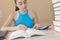 Young student sitting between books and calculate. Young Girl with bills and calculator in the living room at home