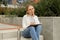 Young student study with notebook in park. Drinking water, hot tea or coffee from reusable metal bottle. Writing