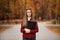 Young student with surprised face looks out of folder in red checkered shirt. Portrait of clever young woman