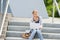 Young student woman sitting on university steps