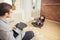 Young students doing homework while sitting on sofa and woman sitting on floor