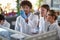 Young students observe a chemical reaction in a test tube in a laboratory. Science, chemicals, lab, people