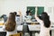 Young students raising hands in a classroom