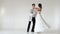 Young and stylish ballet couple dancing on white