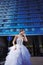 Young stylish bride on blue glass office building background