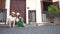 Young stylish couple in straw hats is sitting on the doorstep.