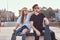 Young stylish couple of a trendy dressed skaters relaxing at a skatepark.