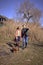 a young stylish couple walking with their cockapoo dog near the river, an unfinished parking lot in the background