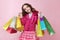 young stylish girl Flirty teenager posing for a portrait on isolated background holding many shopping bags with a bold smile on h