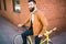 Young stylish man with a beard sitting on bicycle on a brick background