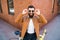 Young stylish man with a beard in sunglasses sitting on bicycle on a brick background