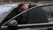 Young stylish man in black sunglasses driving a car.