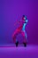 Young stylish man, break dancing, hip-hop dancer practicing solo in casual clothes isolated over purple background in