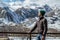 Young stylish man in profile standing on the rooms terrace on the background of beautiful mountain landscape of Kazbek