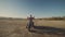 Young stylish motorcyclist sitting on his motorbike in the desert road during sunset