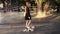 Young, stylish red headed girl walking by empty skatepark with her loving dog. Slow motion of pretty girl in black dress