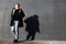 Young stylish redhead man in trendy outfit posing against urban background