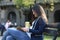 Young stylish woman in the city, sitting on a bench, reading and drinking coffee