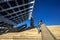 Young and stylish woman is standing on stairs next to the huge solar panel in Port Forum, Barcelona, Spain.