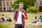 Young successful blond nerdy student is standing with backpack a