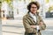 A young successful businessman in eyewear smiling broadly posing outdoors. Male entrepreneur resting in the city street. Smart guy