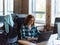 A young and successful businesswoman with vibrant orange hair engages in focused work within a modern office, showcasing