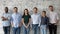 Young successful diverse businesspeople standing in row looking at camera