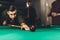 young successful handsome man playing in russian pool at bar
