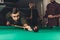 young successful handsome man playing in russian pool at bar