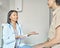 Young supportive afro american female doctor reaching hands out to help middle-aged woman patient