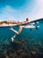 Young surf girl at surfboard underwater in sea