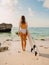 Young surf girl with surfboard watching at ocean. Surfer woman standing at beach.