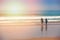 young surfer couple going into the ocean at sunrise