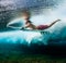 Young surfer dives under the ocean wave