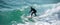 Young surfer enjoys the waves confronting the surf by surfing the rougher waters after a morning rain storm