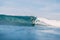 Young surfer girl at surfboard on overhead wave.