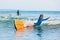 Young surfer learning ride and fall from surfboard with fun