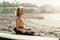 Young surfer man sitting on sand next to surfboard