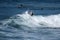 A young surfer re-enters the crest of a wave