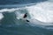 A young surfer re-enters the crest of a wave