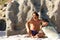 Young surfer sitting in sand with surfboard