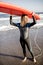 Young surfer with surfboard on the beach