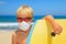 Young surfer wearing sunglasses, protective mask on sea beach