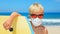 Young surfer wearing sunglasses, protective mask on sea beach