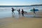 Young surfers head for the surf at Oak Street Beach in Laguna Beach, California.