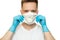 Young surgeon doctor in latex protective gloves puts on white protection mask on white background. Man in medical gloves and on