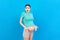 Young surprise or shocked woman pregnant isolated colored background. expression female