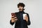 Young surprised indian man in headphones with coffee and phone